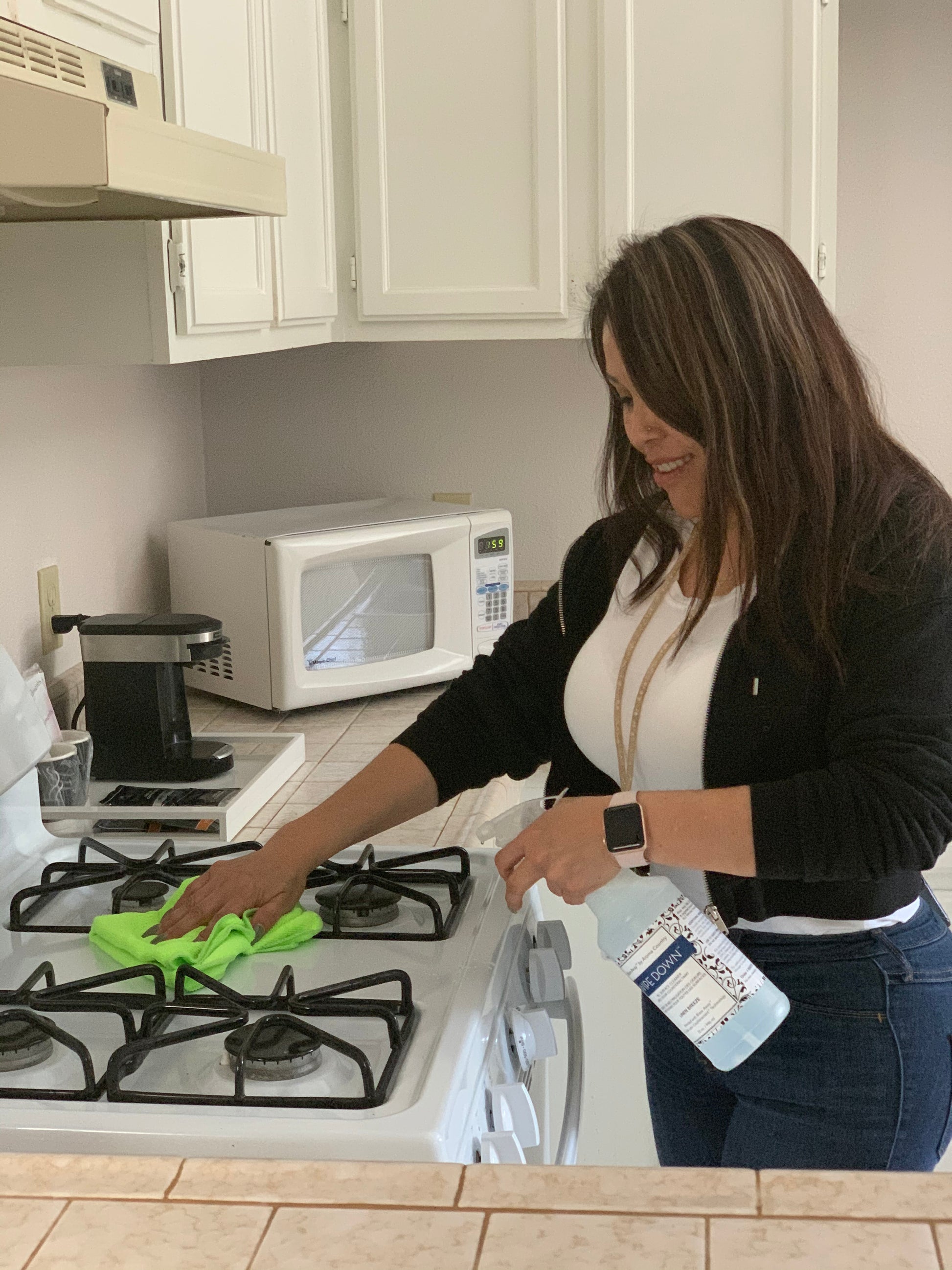 Woman using Wipe Down to clean a stovetop. 